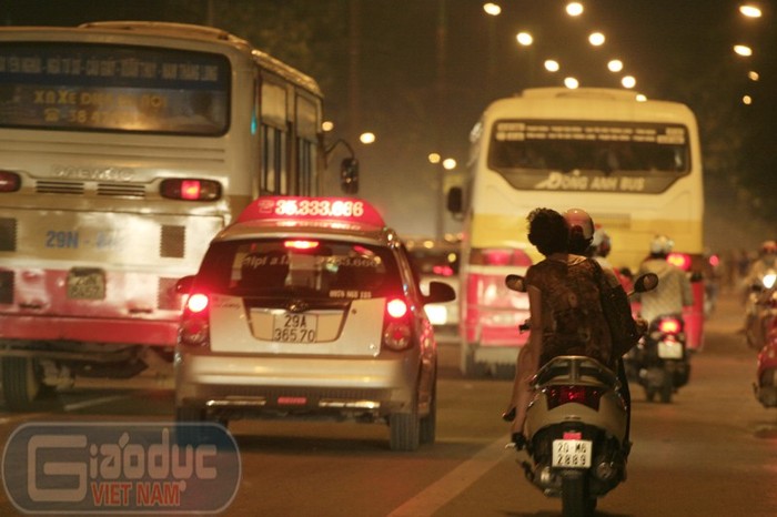 Xâm xẩm tối, đi trên đường Hà Nội là một màu vàng mờ của khói bụi và các hàng xe bus xếp hàng hai đi trên đường.